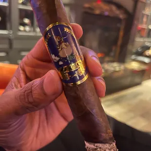 a hand holding a cigar