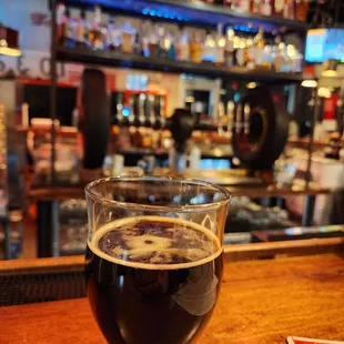 a glass of beer on a bar counter