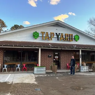 a man and woman standing outside of a restaurant