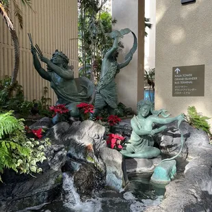 a fountain with statues of children playing in it