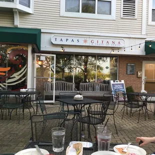 a woman sitting at a table outside a restaurant