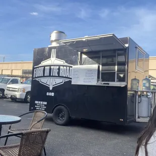 a woman sitting at a table in front of a food truck
