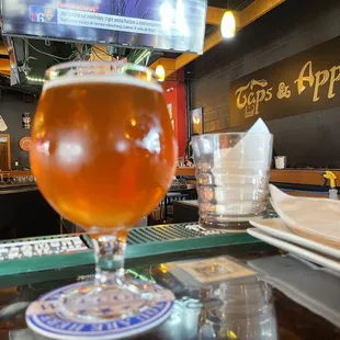 a glass of beer on a bar