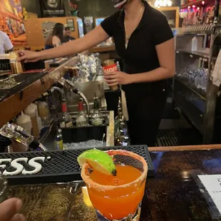 a woman serving a drink at a bar
