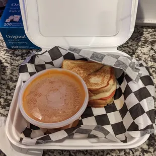 Grilled cheese and tomato with a cup of tomato soup.