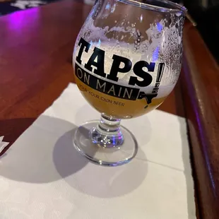 a glass of beer on a napkin