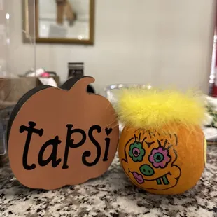 an orange with a yellow fuzzy ball on top of it