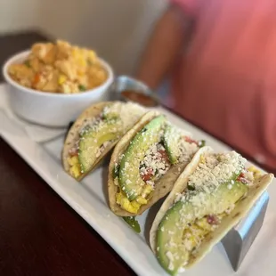 a plate of tacos and a bowl of macaroni and cheese