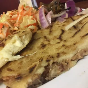 Inside of my cheese pupusa and pork , bean , and cheese pupusa .