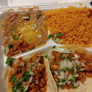 Two grilled chicken tacos with rice and beans.