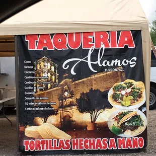 a taqueria sign in front of a tent