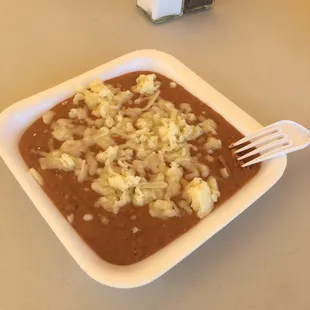 Side of beans with cheese on top. Two thumbs up.