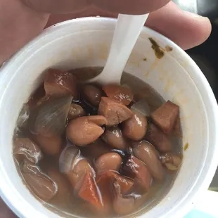 a hand holding a cup of soup