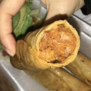 a hand holding a taqueria roll