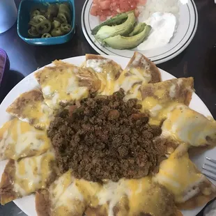 a plate of nachos with ground beef and cheese