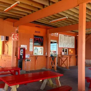 Two order windows &amp; shaded picnic tables in front..