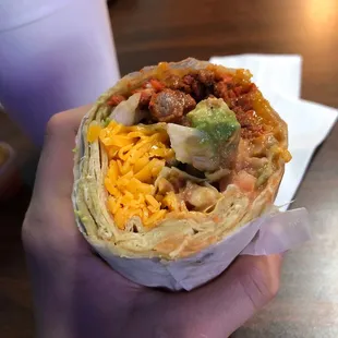a hand holding a burrito
