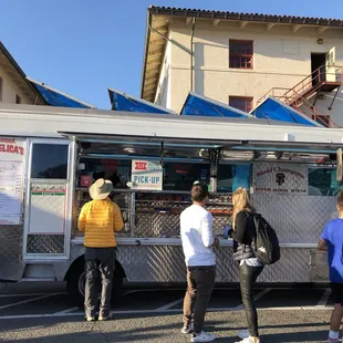 a group of people standing in front of a food truck