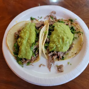Tacos filled with Carnitas, and topped with Guacamole