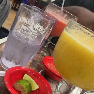 a glass of orange juice and a plate with a slice of lime