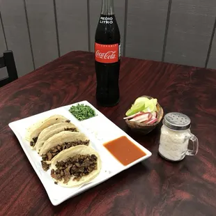 a plate of tacos and a bottle of coke