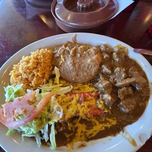 Tejano Plate: Enchiladas with Carne Guisada side rice &amp; beans garnish with lettuce and guacamole. Tortillas on the side.