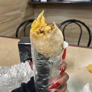 a person holding a burrito