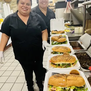 two women carrying trays of sandwiches