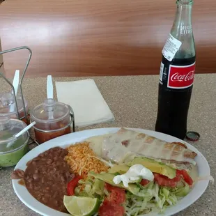 Chimichamga covered in in queso (cheese sauce) with un Coke de Mexico. Delicious