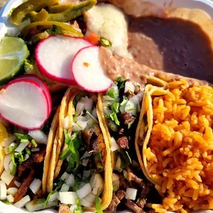 Taco plate ($14). Left to right: Al pastor, carnitas, carne asada. There&apos;s romaine salad in ranch beneath pickled jalapenos, upper left.