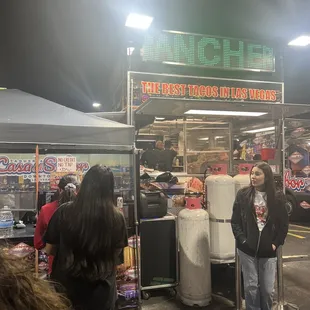 a man standing in front of a food stand
