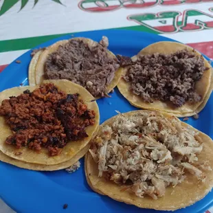 three different types of tacos on a blue plate