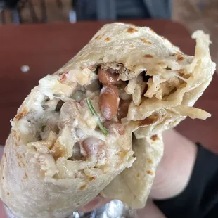 a hand holding a burrito