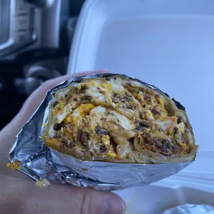 a hand holding a burrito