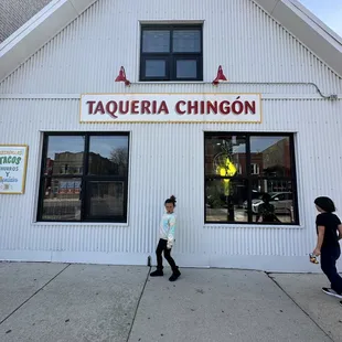 a woman walking in front of a restaurant