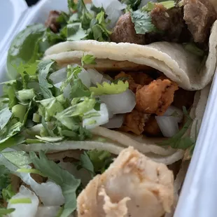 Chicken, Al Pastor, Asada tacos with cilantro, onion. Hot sauce and lime on the side.