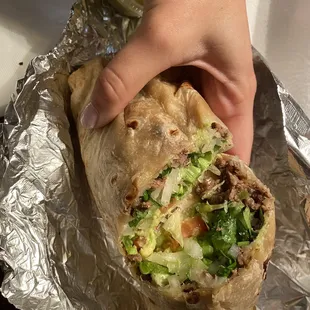 Steak burrito fully dressed (lettuce, cheese, tomato, cilantro, avocado)