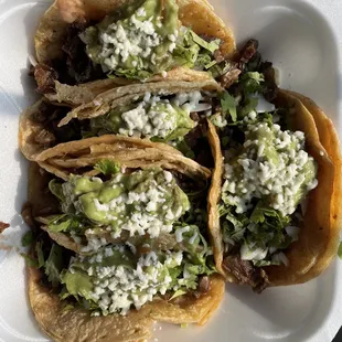 Carne asada tacos with guacamole and refried beans.