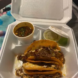 a tray of tacos and a bowl of salsa
