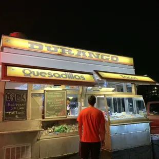 a man standing in front of a food cart