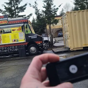 a person taking a picture of a food truck