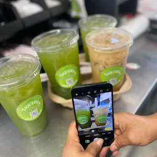 a person taking a picture of their drinks