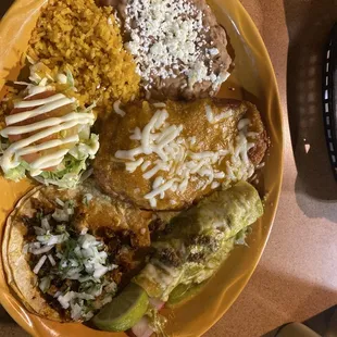 Combination plate with a beef enchilada with green sauce, chili relleno, El Pastor taco, refried beans, and rice