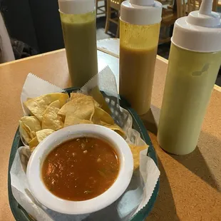 Homemade puffy tortilla chips, fresh salsa, and three types of hot sauce, guacamole, green sauce, and mild red