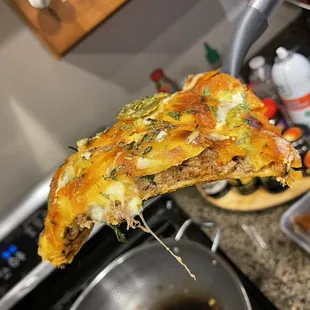 a person holding a piece of pizza