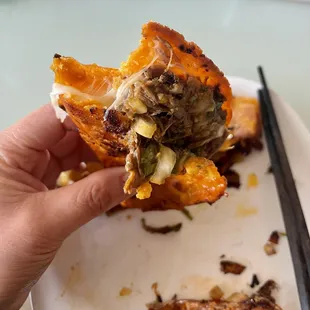 a hand holding a piece of food