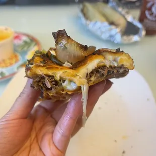 a hand holding a taqueria del taco