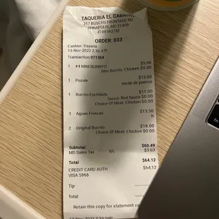 a receipt on a table next to a laptop