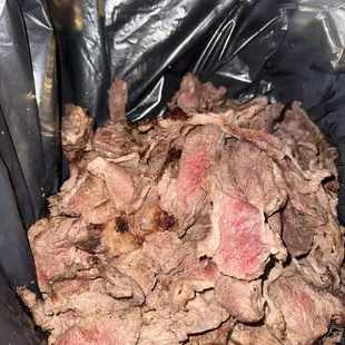 Meat inside a garbage back being placed into the grill and served to customers :/
