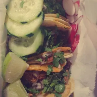 three tacos with cucumbers and onions